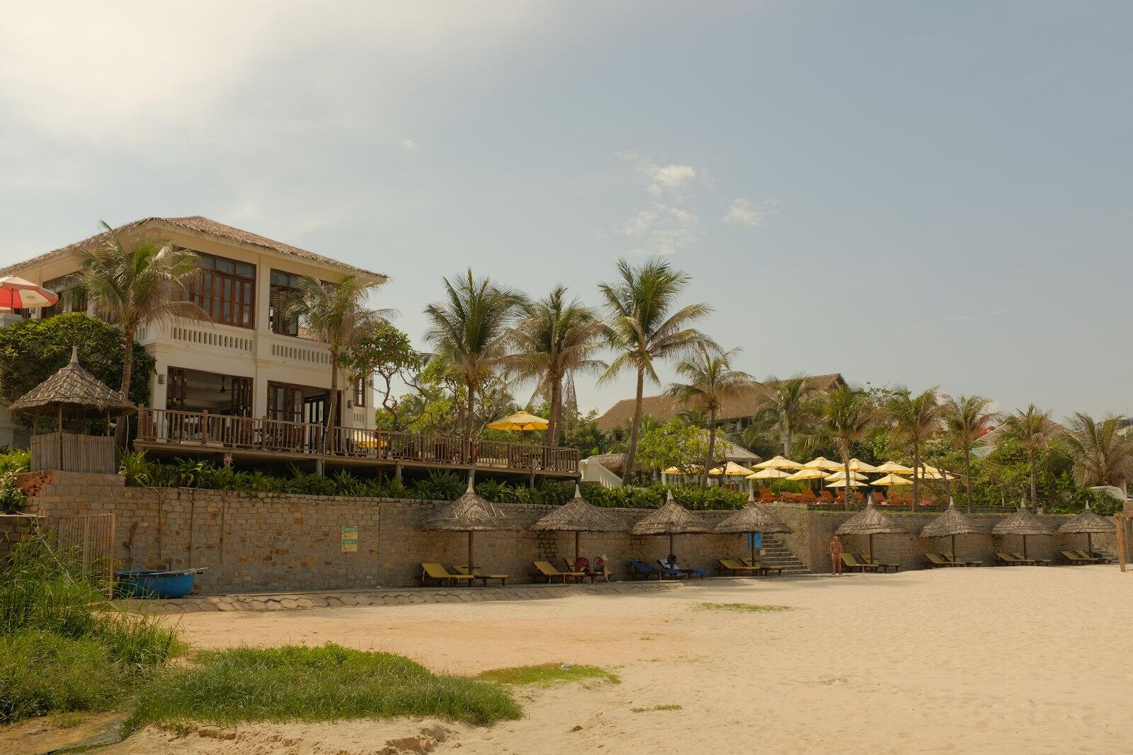 Tropical beach resort building with palm trees and umbrellas — illustrative property style — illustrative style for Island Breeze Villas