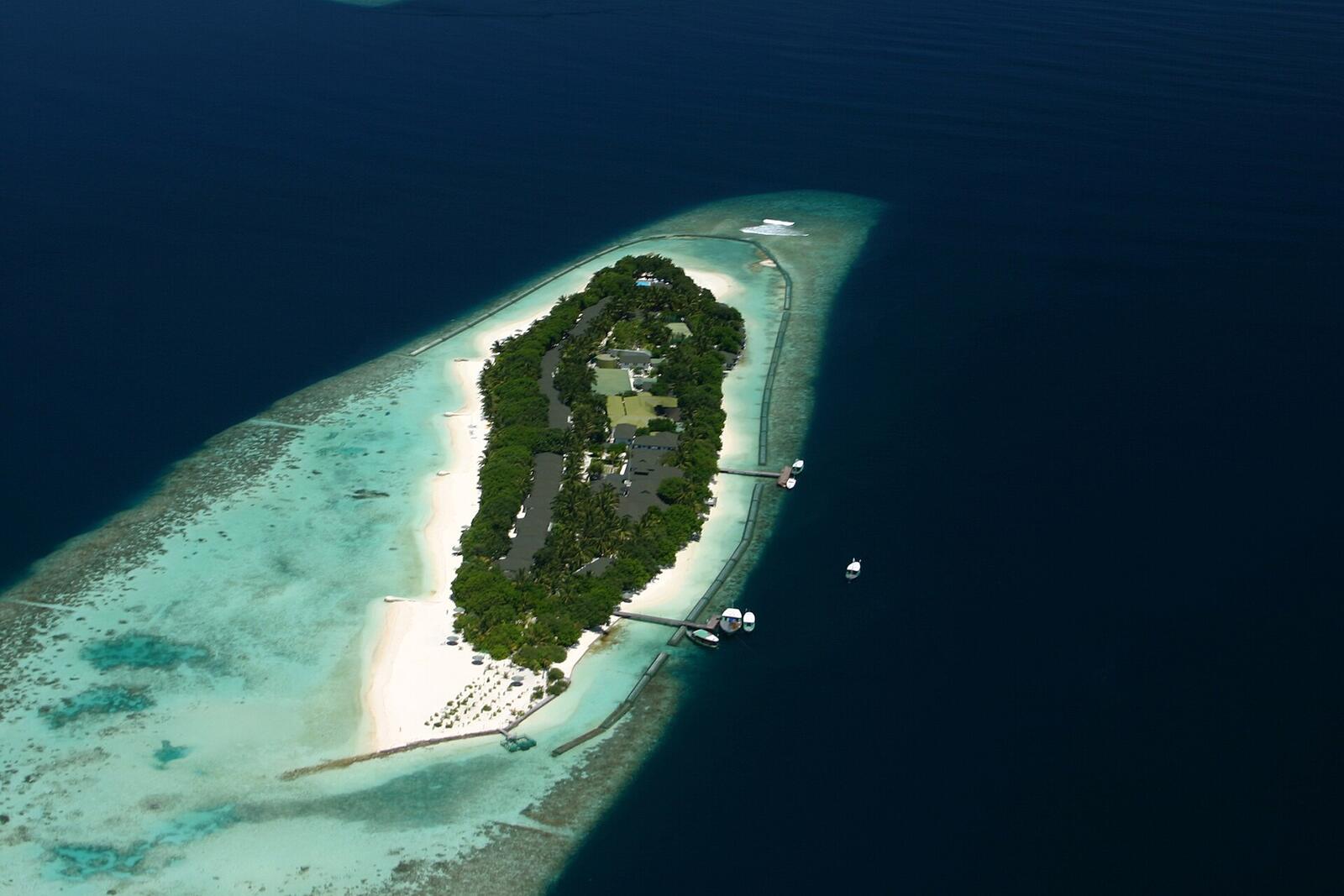 Illustrative accommodation photography for a fictional maldives stay — illustrative style for Emerald Wave Villas