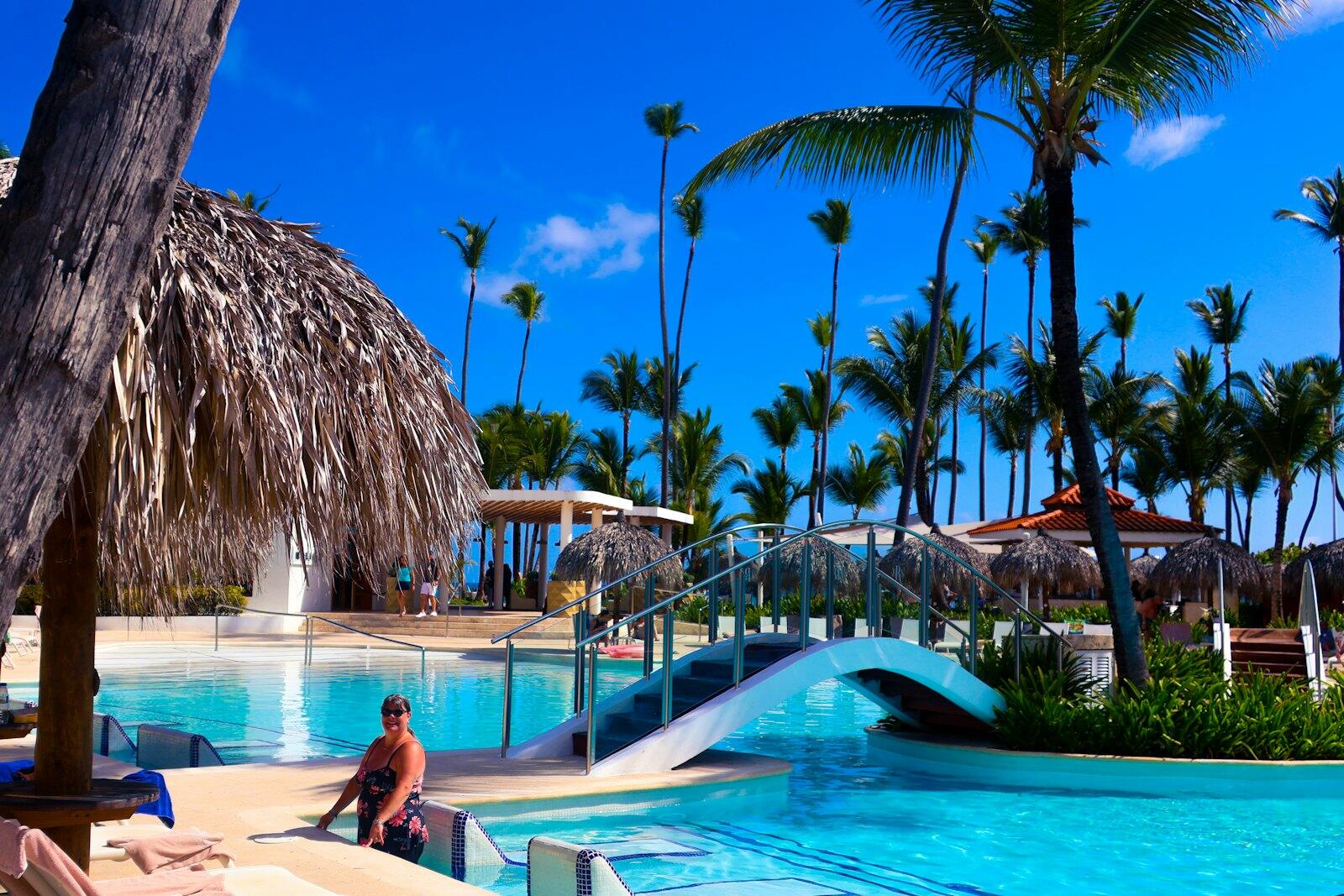 A tropical pool paradise under a bright blue sky — illustrative property style — illustrative style for Rainforest Edge Lodge