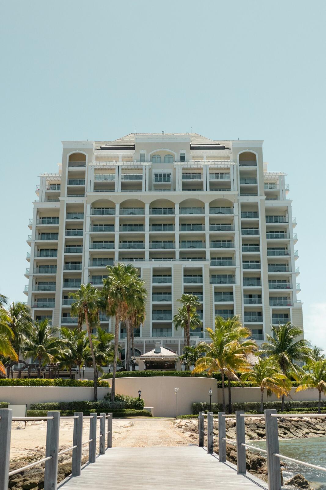 A large white building sitting on top of a beach — illustrative property style — illustrative style for Reefside Family House