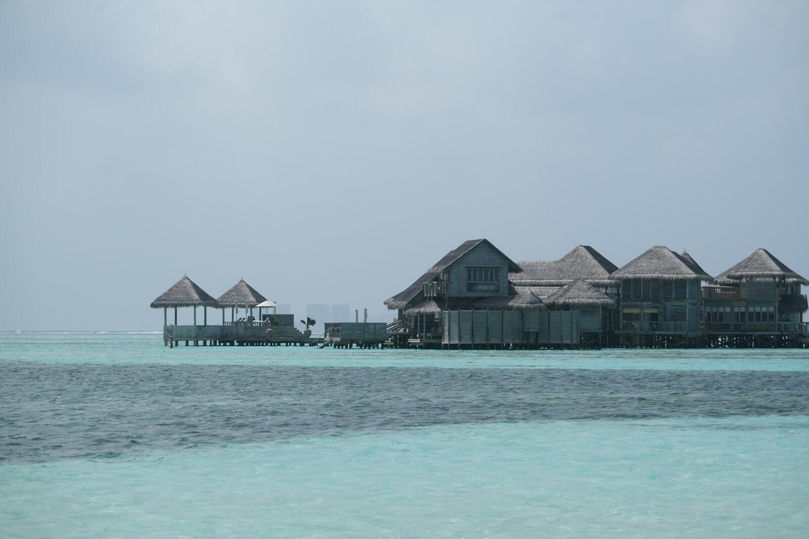 Overwater bungalows on a clear turquoise sea — illustrative property style — illustrative style for Aurelia Lagoon Retreat