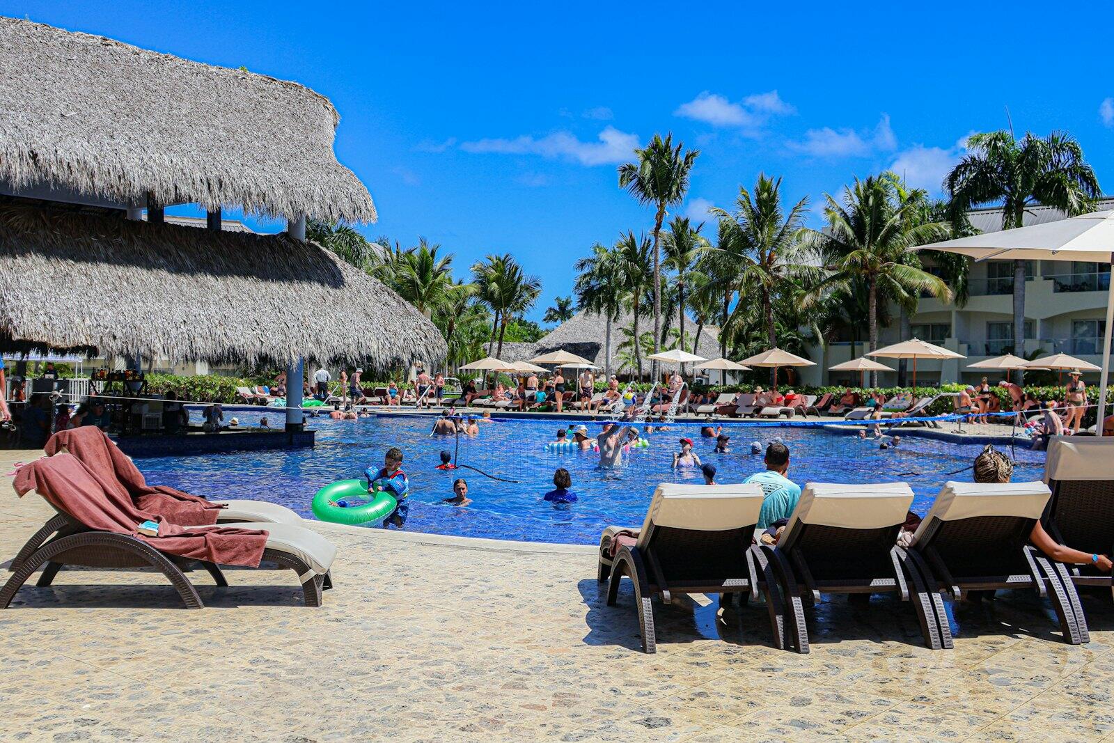 People are swimming and relaxing at a beautiful resort pool — illustrative property style — illustrative style for Cocoa Grove Retreat