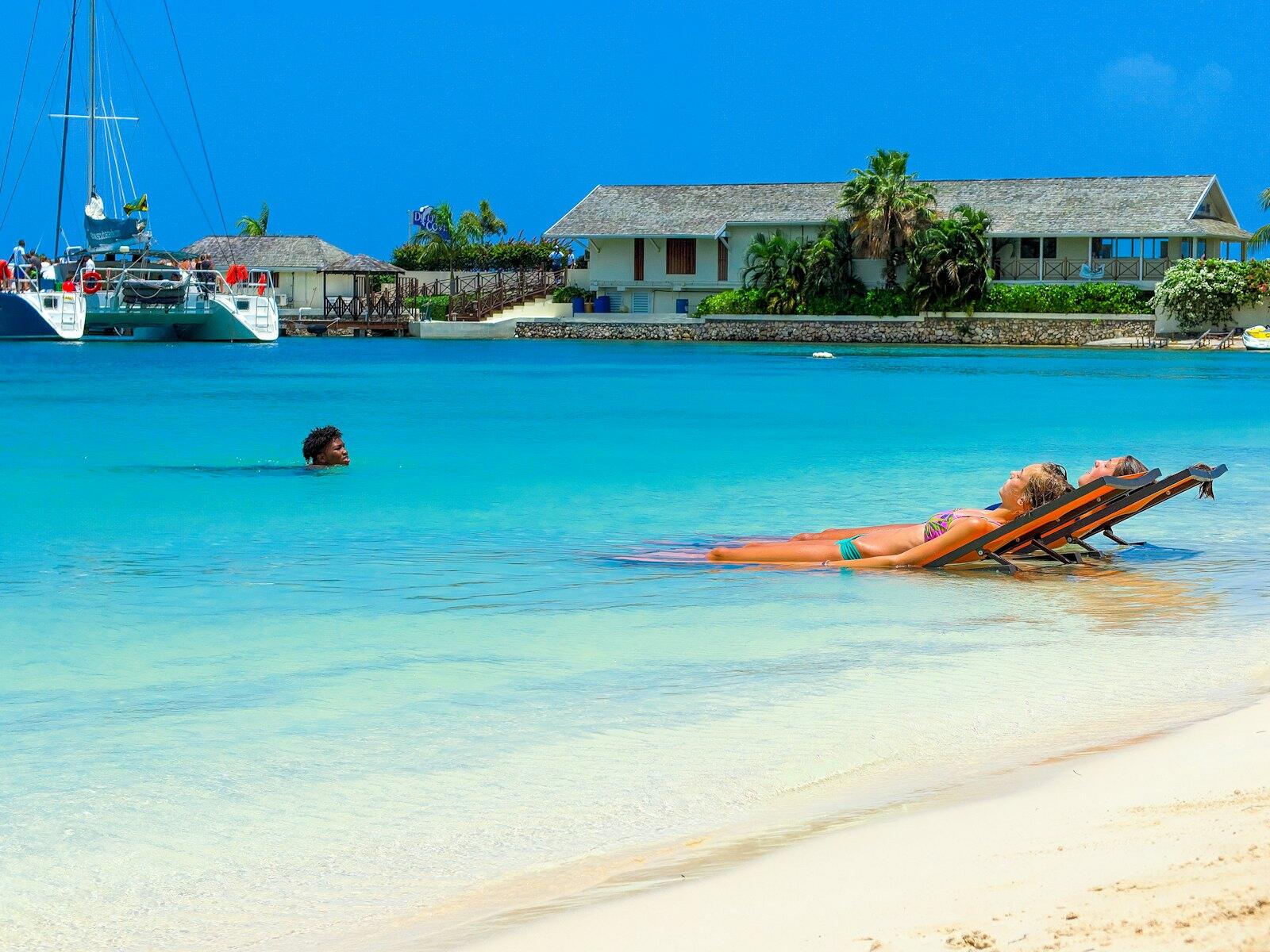 Two women sun bathing and another man swimming on blue body of water during daytime photo – Free Blue Image on Unsplash (https://unsplash.com/photos/two-women-sun-bathing-and-another-man-swimming-on-blue-body-of-water-during-daytime-0wEsuZXkF2o) — illustrative property style — illustrative style for Seabreeze Villas
