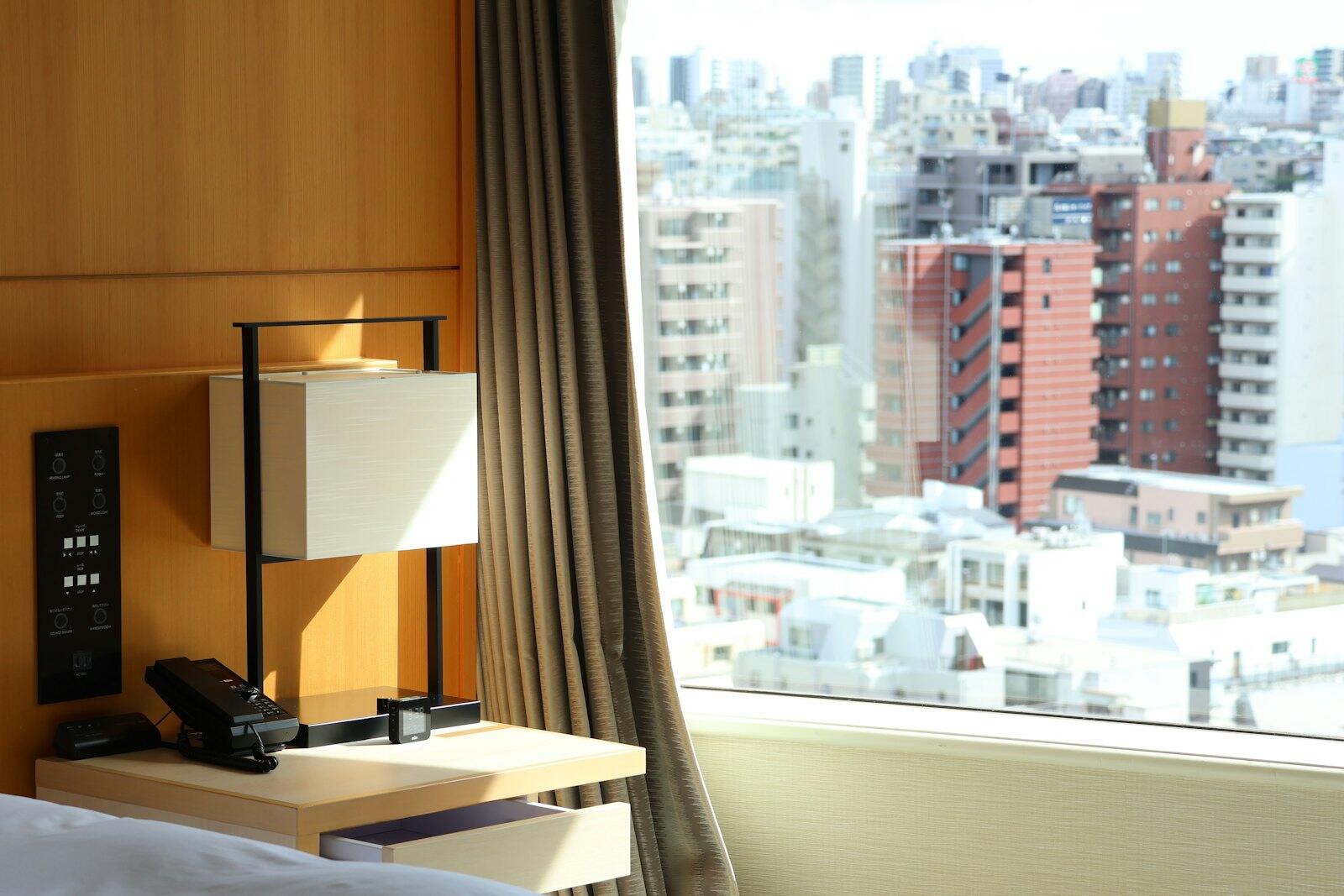 A hotel room overlooks a busy cityscape — illustrative property style — illustrative style for Osaka Riverside Rooms