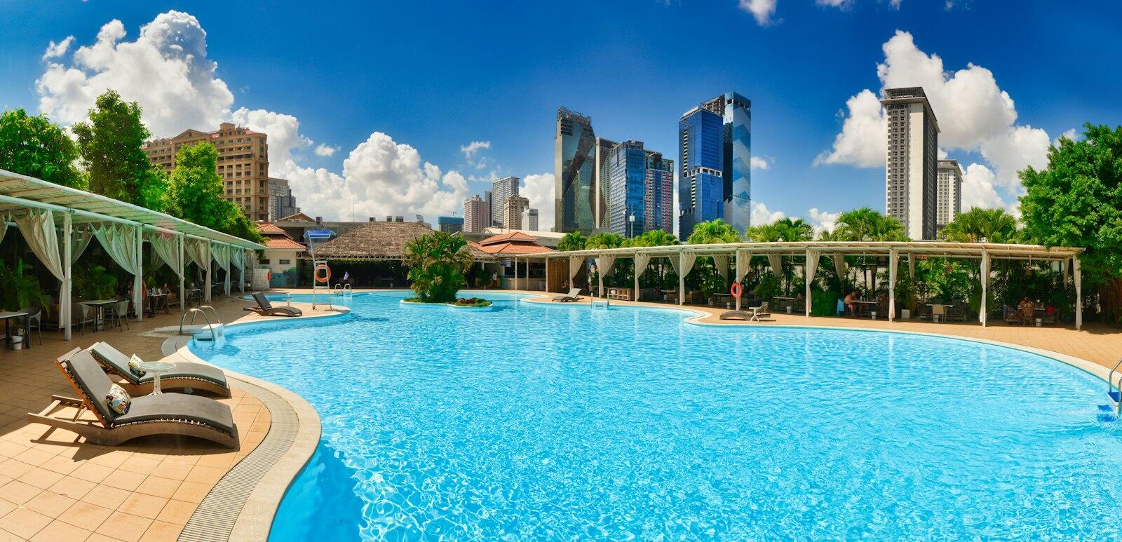 A large swimming pool with lounge chairs around it — illustrative property style — illustrative style for Kep Coastal House