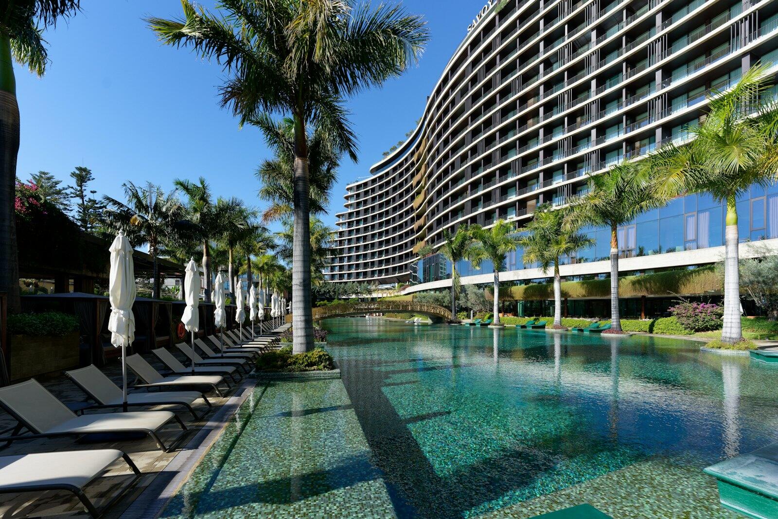 a hotel with a pool and lounge chairs next to it — illustrative property style — illustrative style for Lisbon Tile House