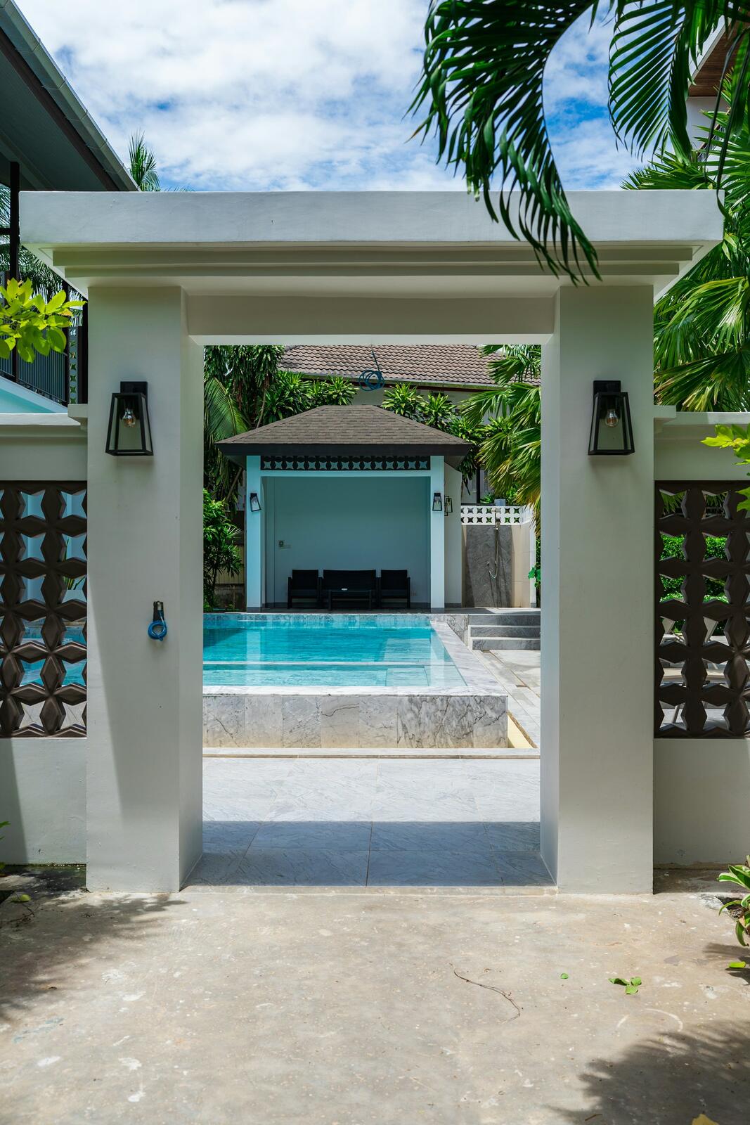 Entrance to a resort pool area with lounge chairs — illustrative property style — illustrative style for Northern Canopy Lodge