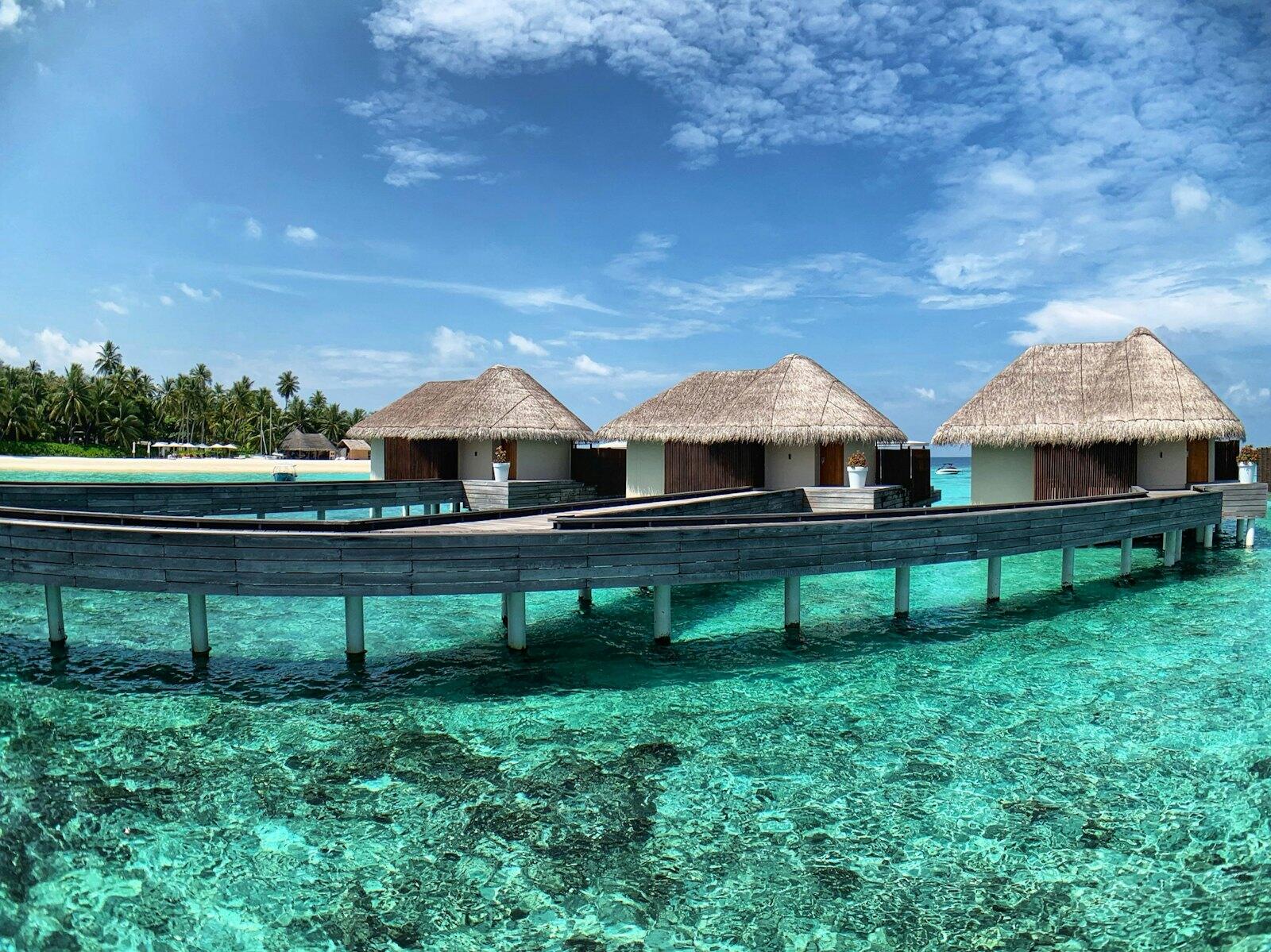 Brown wooden house on blue body of water under blue sky during daytime — illustrative property style — illustrative style for Sandbank House