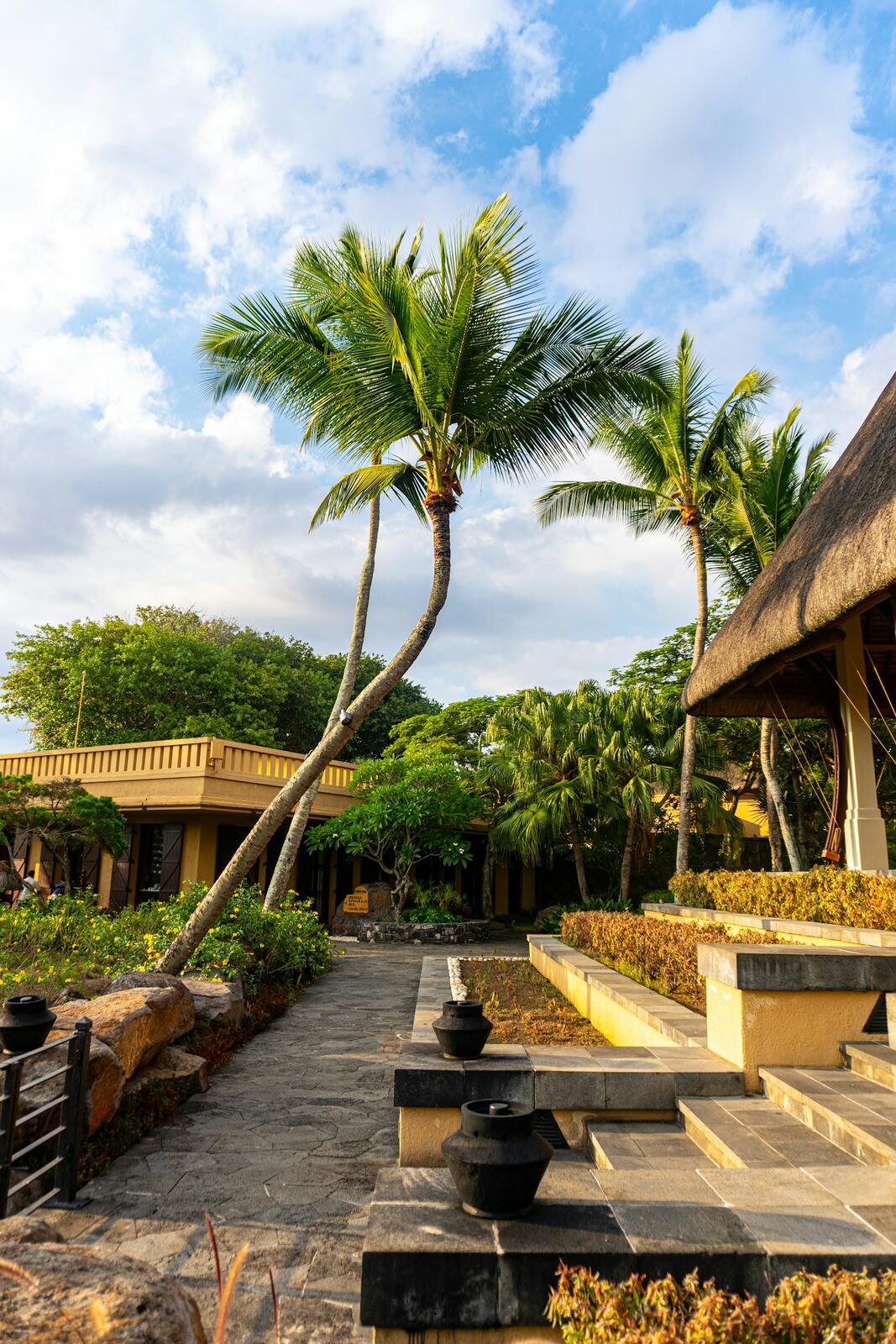 A tropical resort with a thatched roof and palm trees — illustrative property style — illustrative style for Chamarel Country House