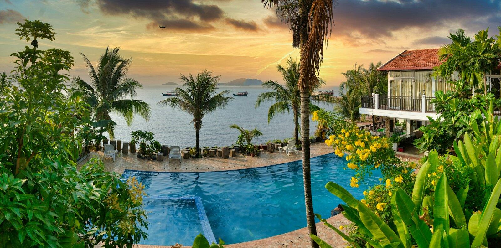 Swimming pool near palm trees during sunset — illustrative property style — illustrative style for Palmwater Island Villas