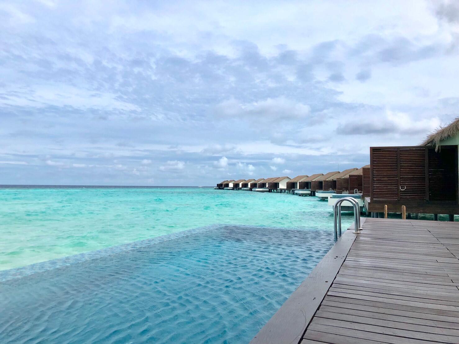 Illustrative accommodation photography for a fictional maldives stay — illustrative style for Barefoot Blue Residence