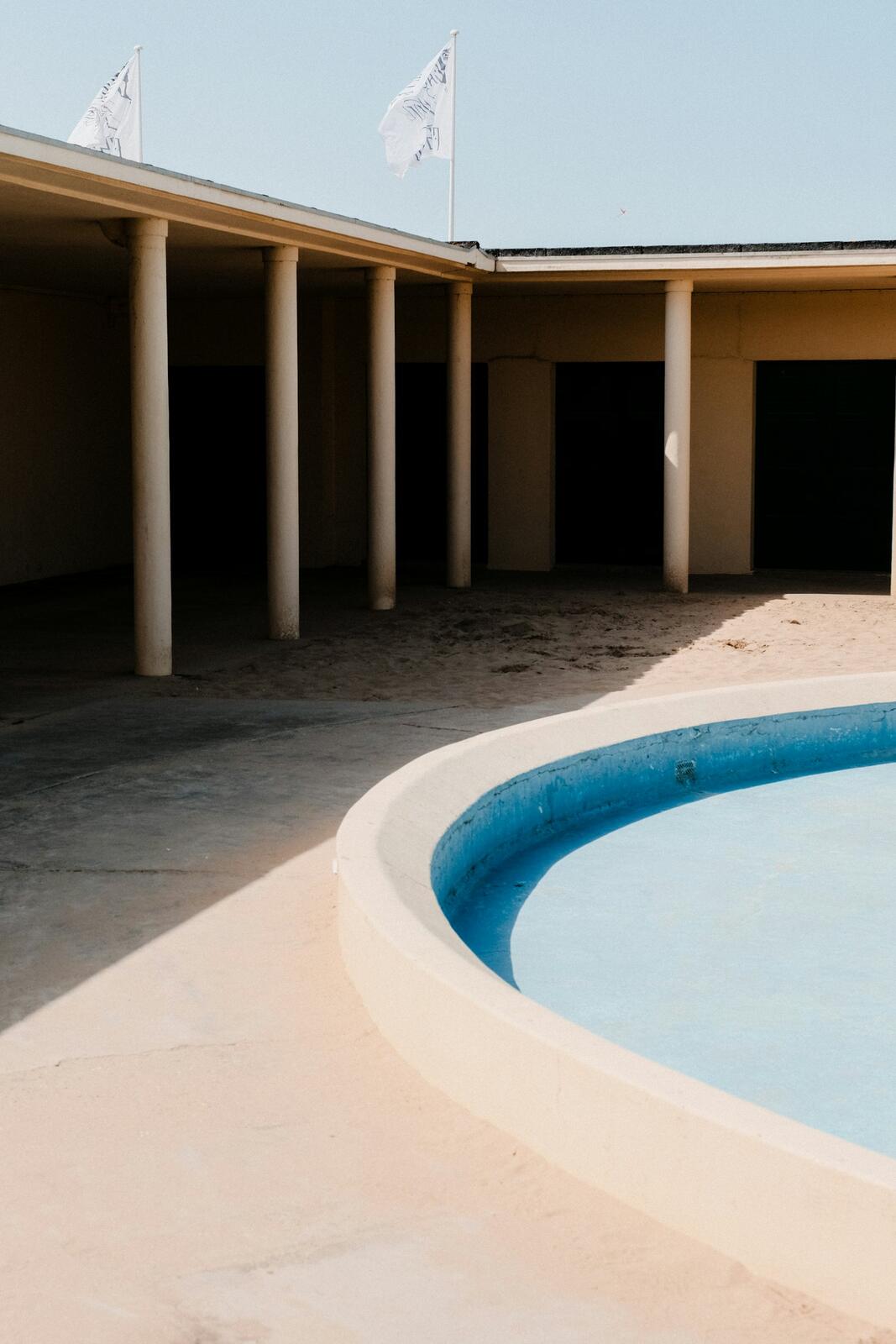 an empty swimming pool in front of a building — illustrative property style — illustrative style for Atlantic Dune Villas